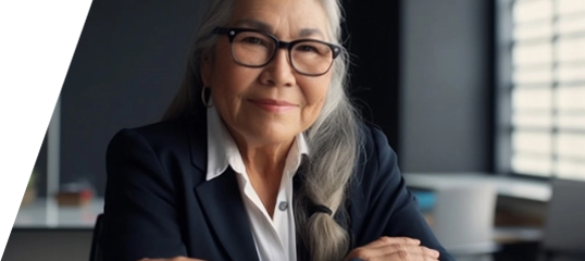 image of indigenous woman with long white hair sitting at a desk in a business setting