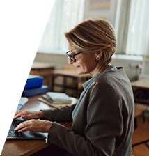 image of woman in a classroom working on a laptop